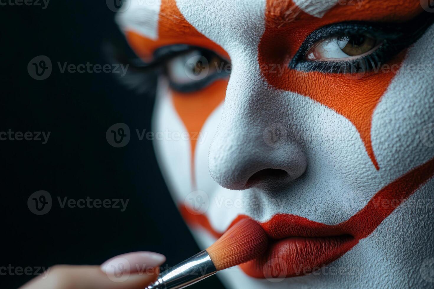 Artistic clown makeup application with orange and white face paint photo