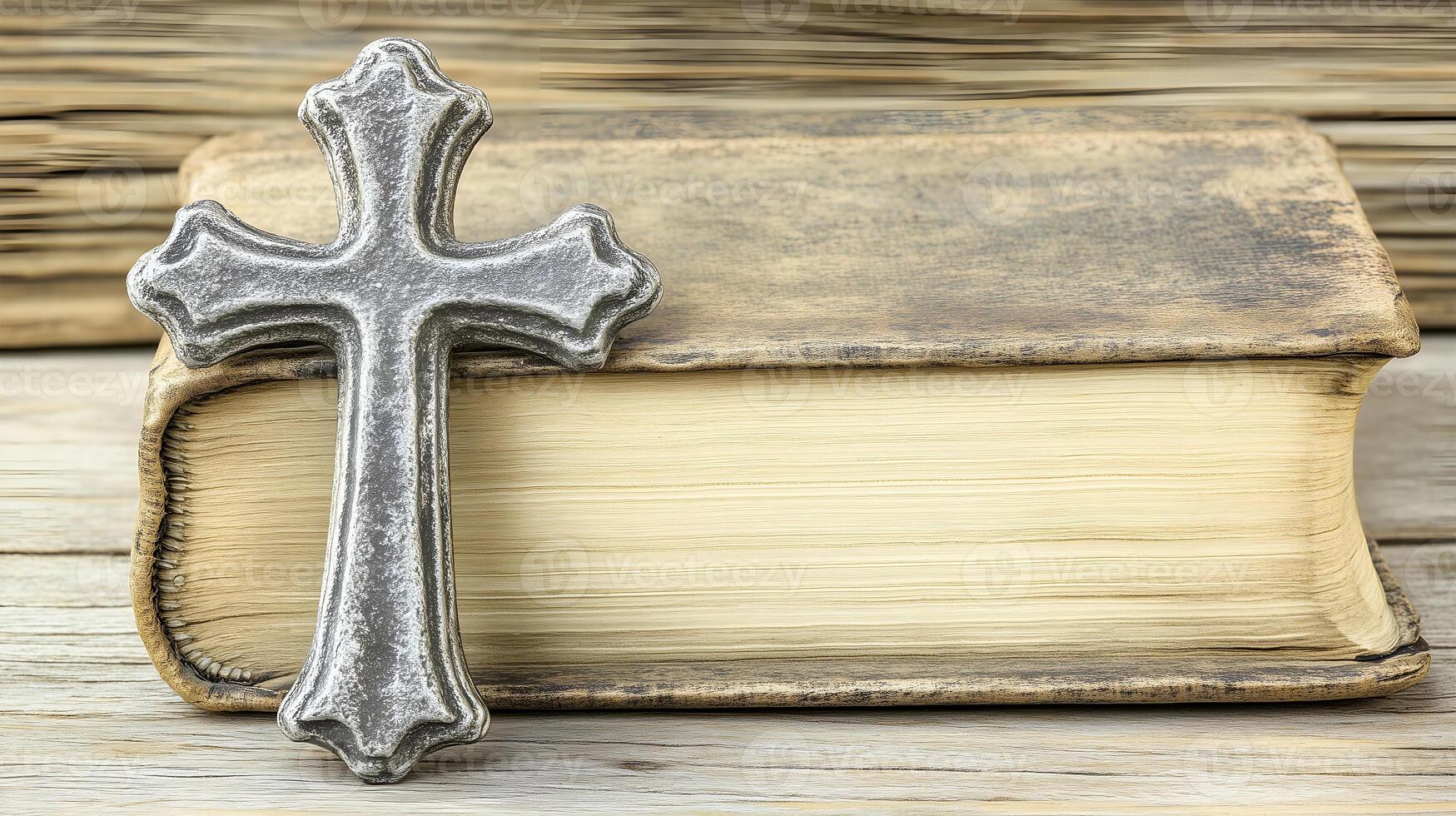Cross resting on an aged book atop a wooden surface with ample negative space photo