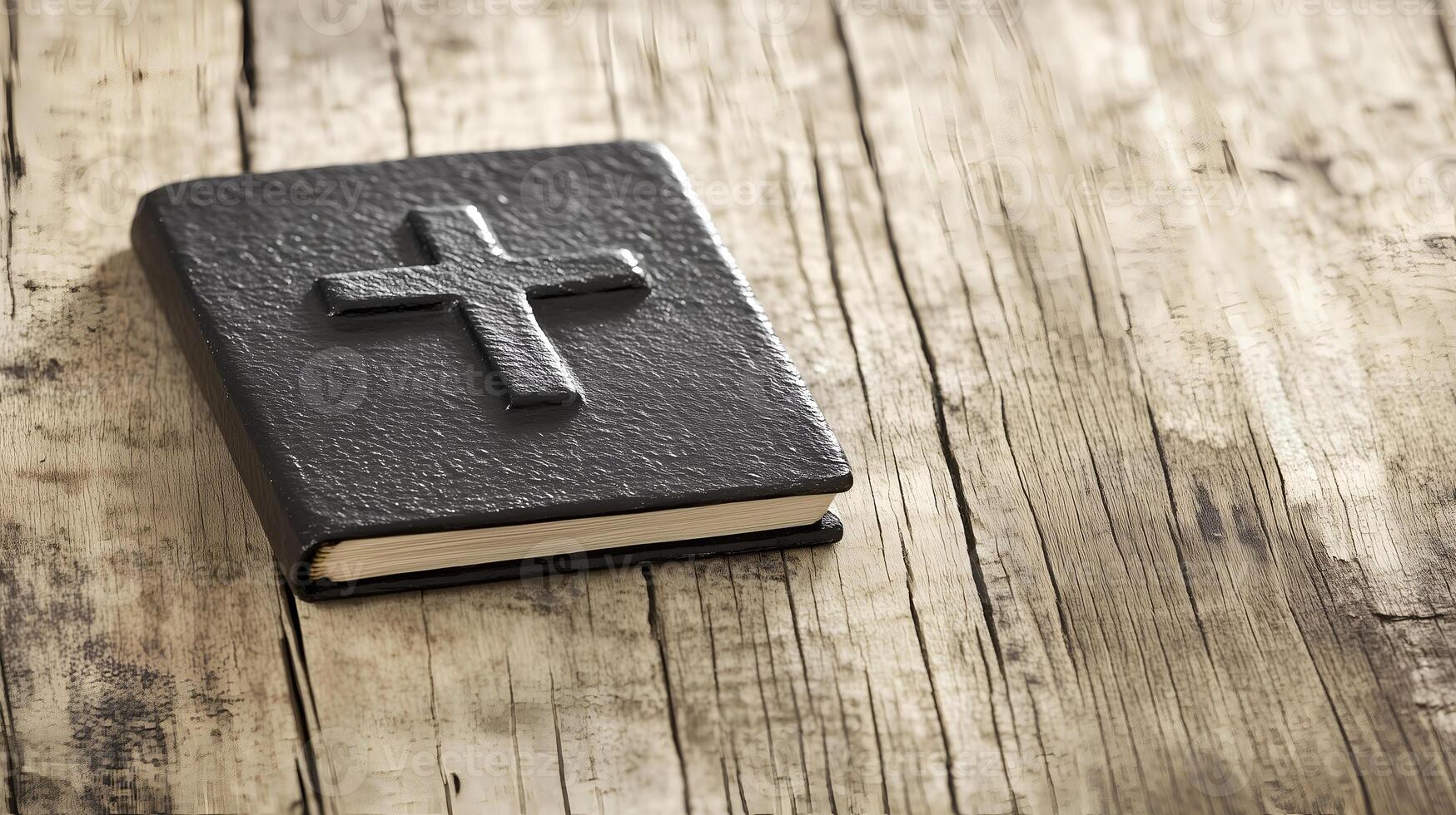 A black book with a cross rests on a rustic wooden background with space, inviting contemplation and reflection photo