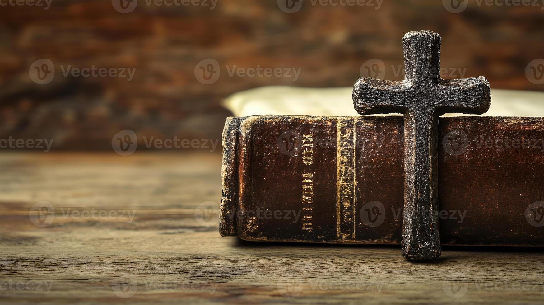 Decorative cross resting on a vintage book against a wooden background with ample space photo