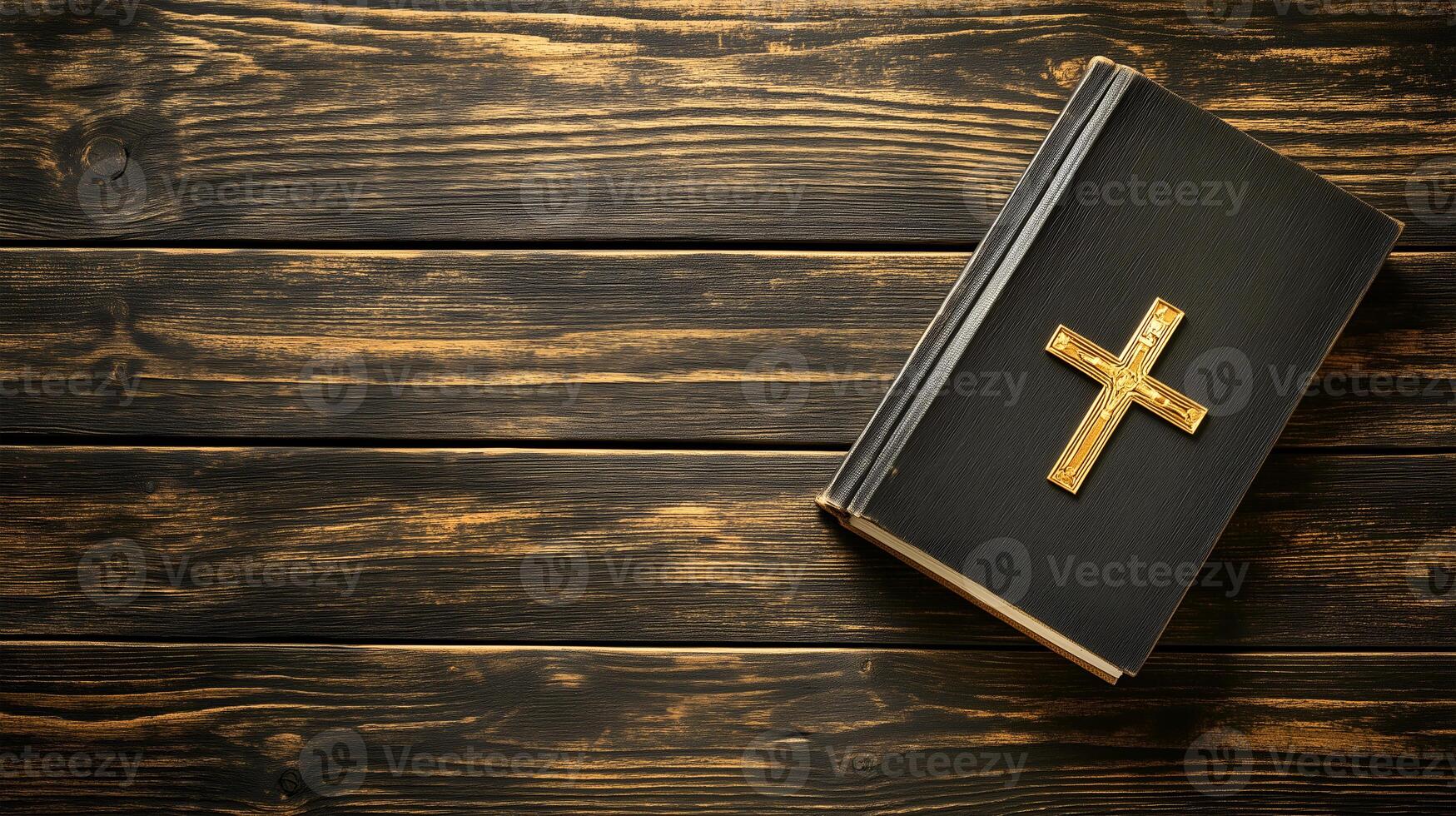A cross placed on a book resting on a wooden surface with ample negative space photo