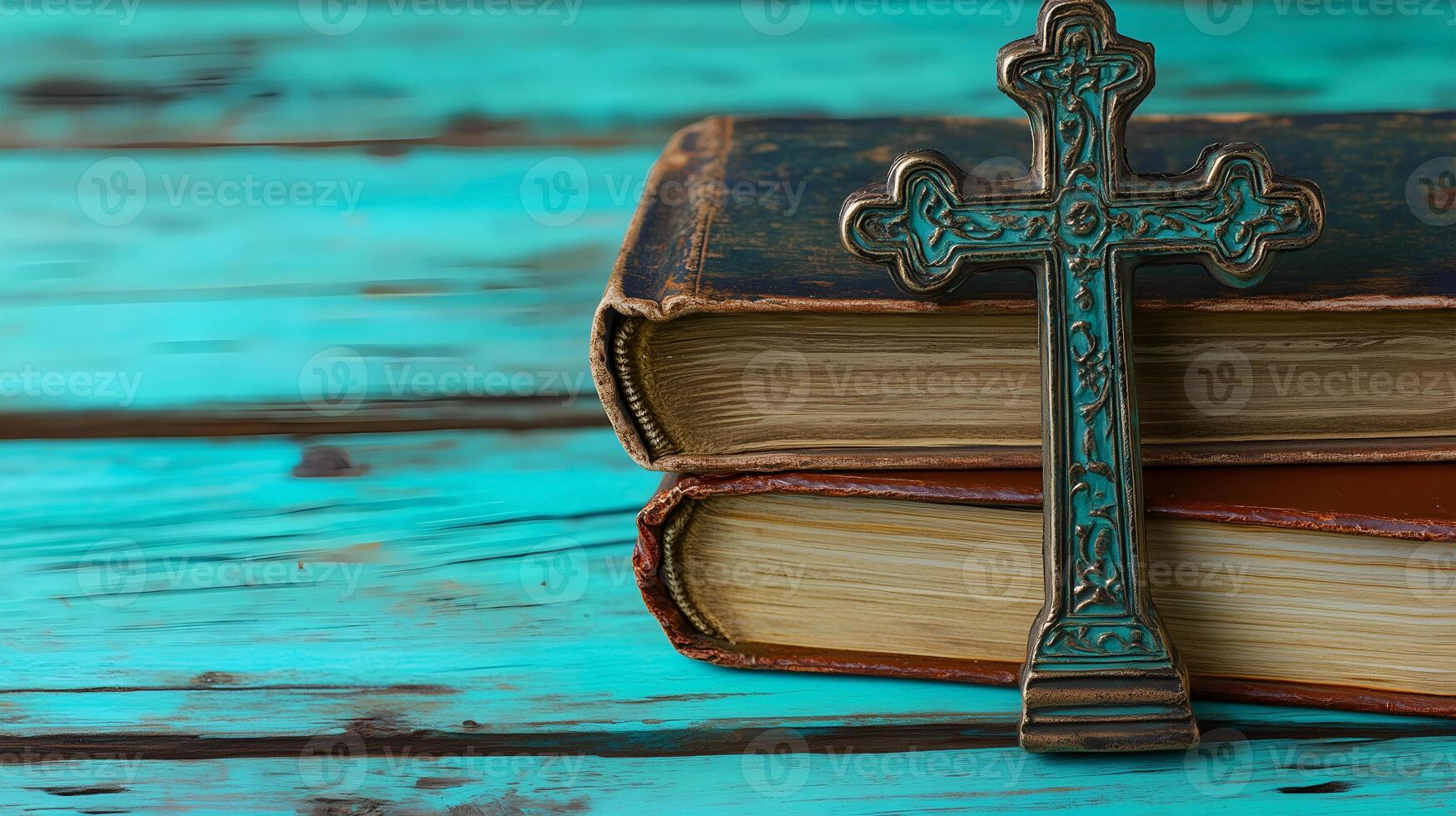 A decorative cross placed on top of vintage books resting on a wooden surface in tranquil setting photo