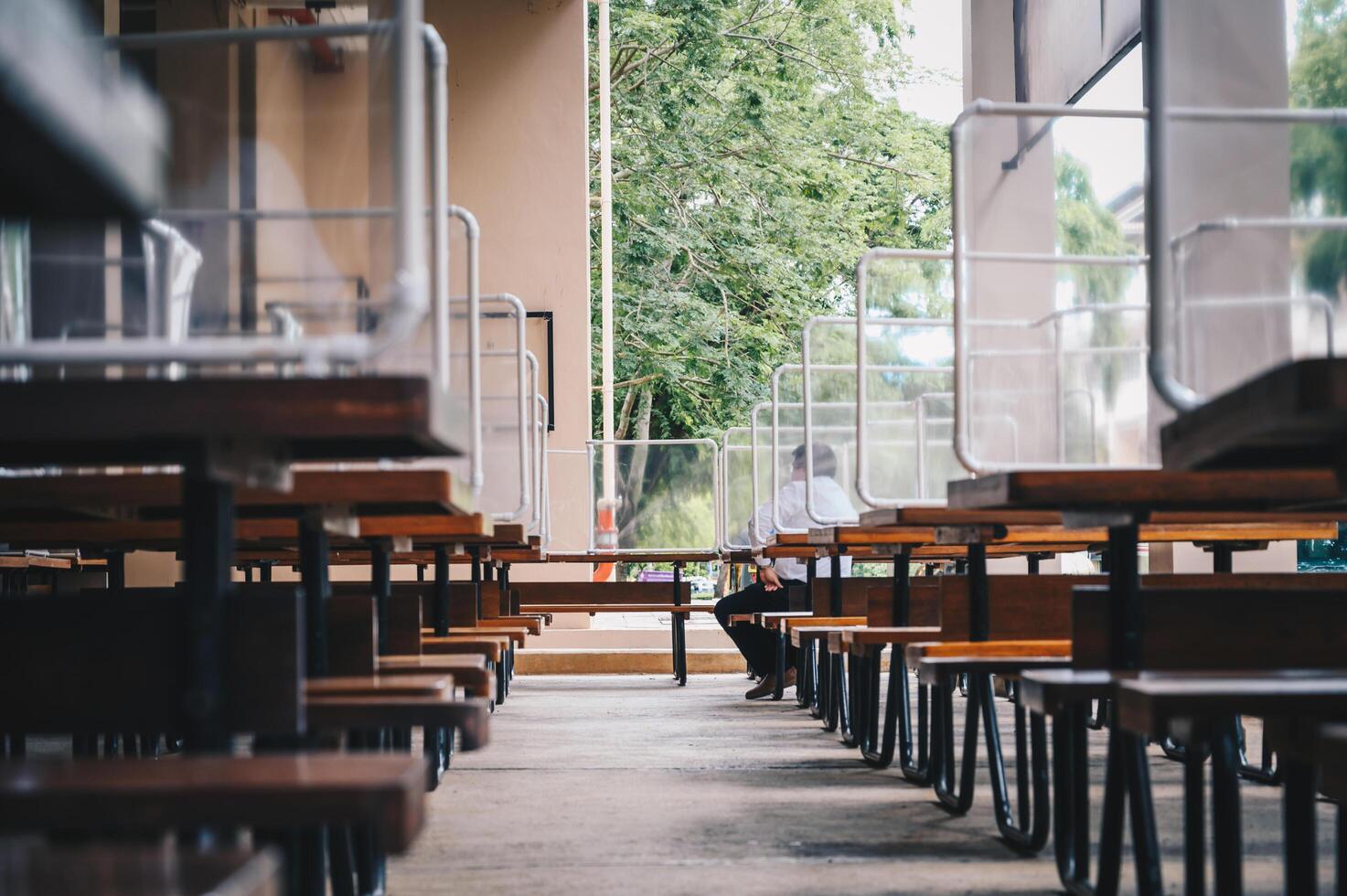 Group of plastic partition setting on table in canteen for reduce and protection the COVID-19 virus spreads in pandemic. Social distancing concept. photo