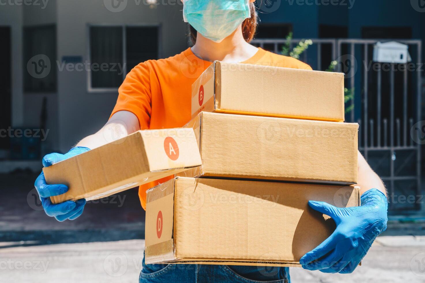 Delivery service courier sending boxes mail to customer while wearing mask and glove for protect herself in covid-19 pandemic outbreak. photo