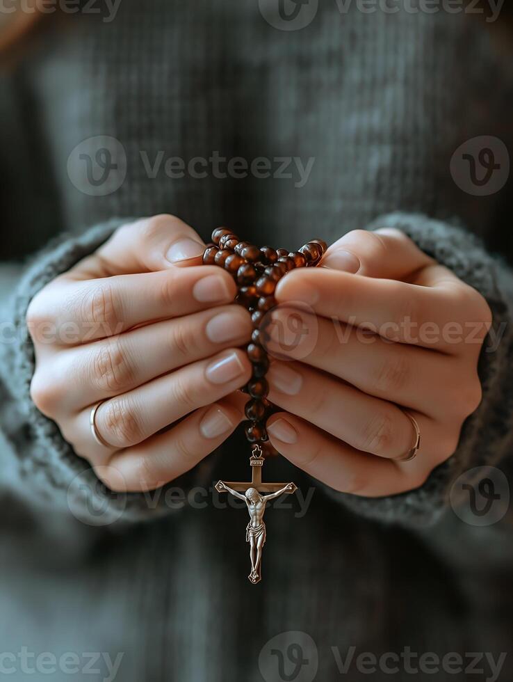 Person praying with rosary beads focusing on faith and reflection during a quiet moment photo