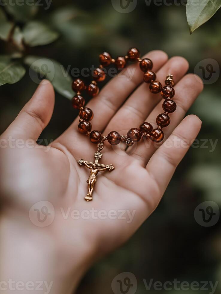 A person holds a rosary with beads and a crucifix, symbolizing Christian faith and prayer photo