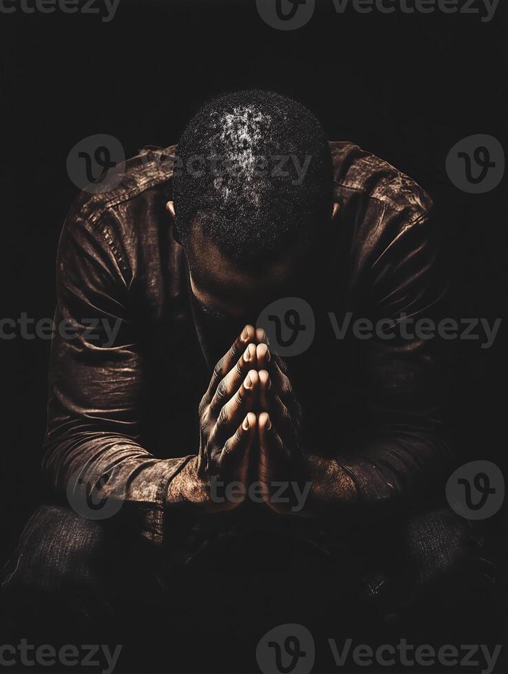 A person praying quietly in a dark space, reflecting deep thoughts and inner peace photo