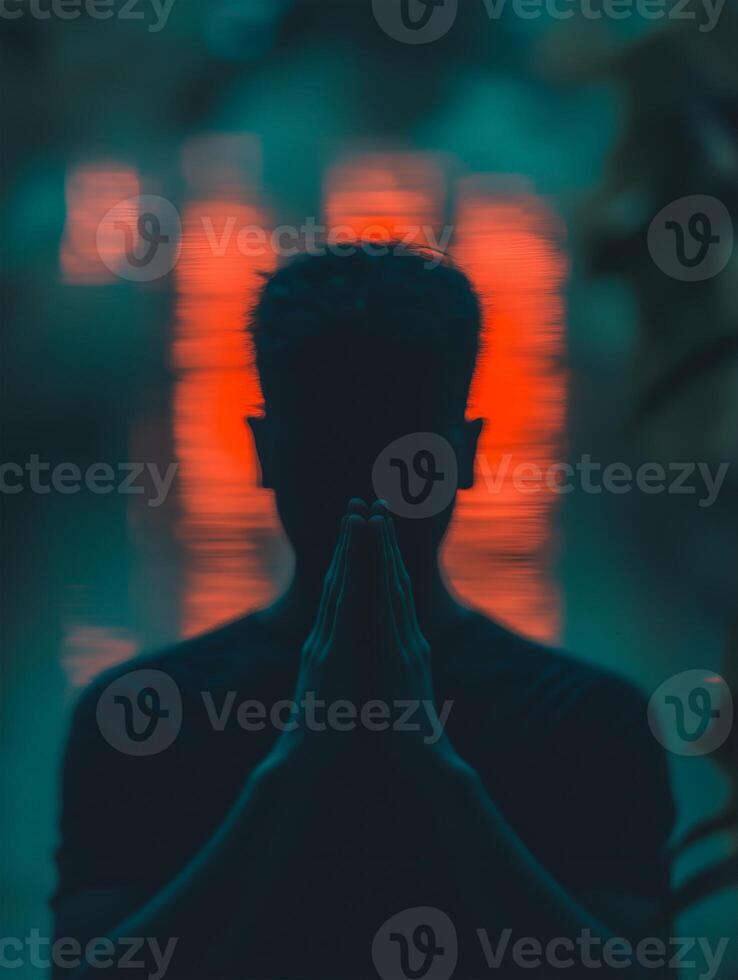 Person praying quietly by a tranquil water surface with soft glowing reflections at dusk photo