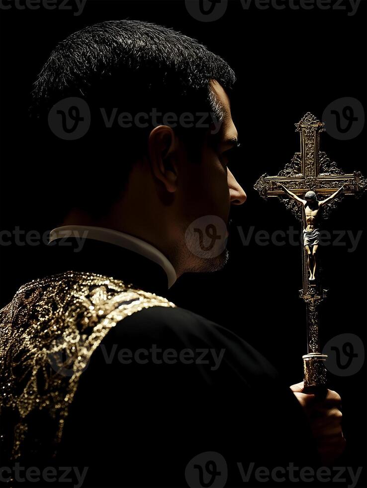 Priest praying in solemn silence while holding a crucifix in a dimly lit space during worship photo
