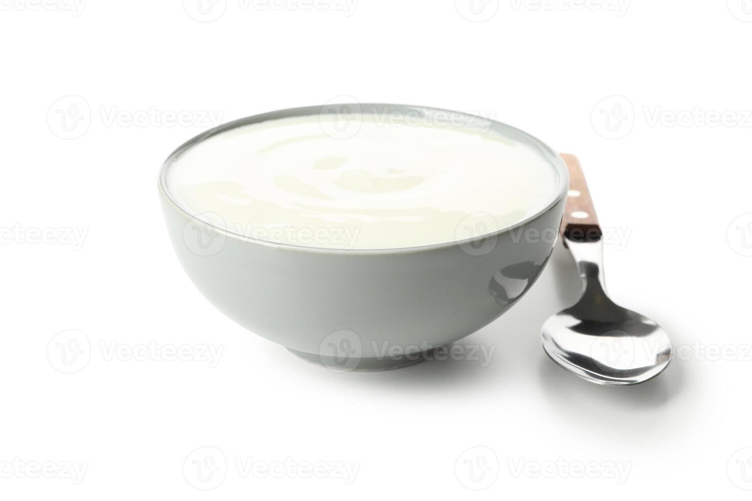 Bowl of sour cream yogurt and spoon isolated on white background photo