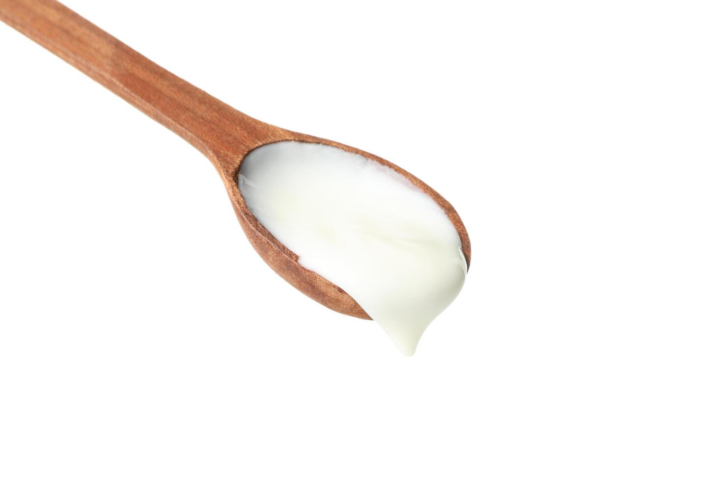 Spoon with sour cream yogurt isolated on white background photo