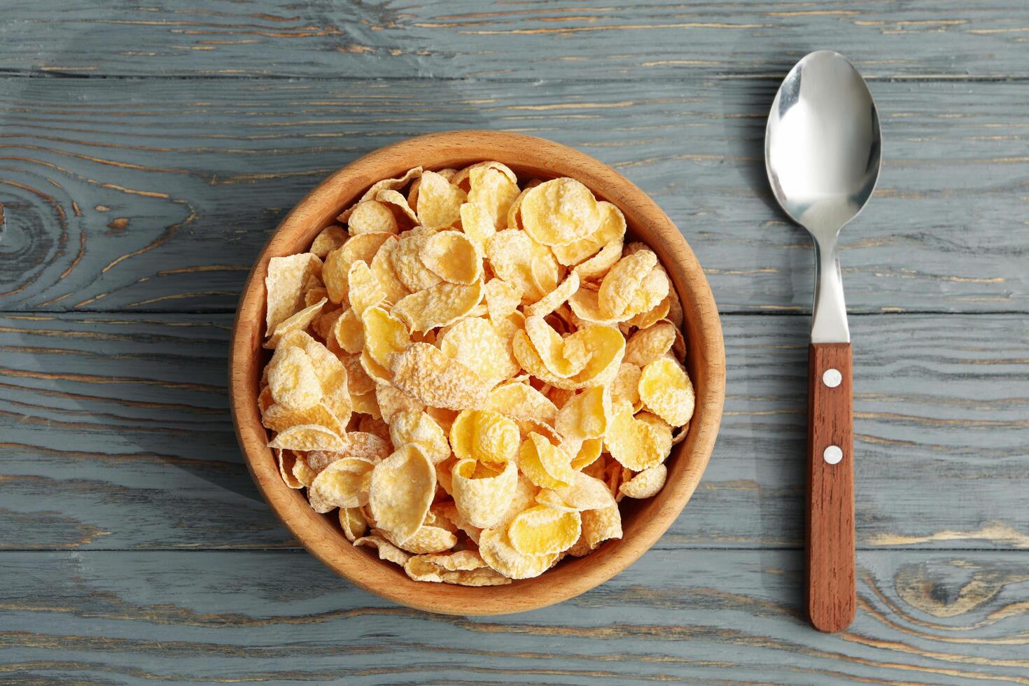 Spoon and bowl of muesli on wooden background photo