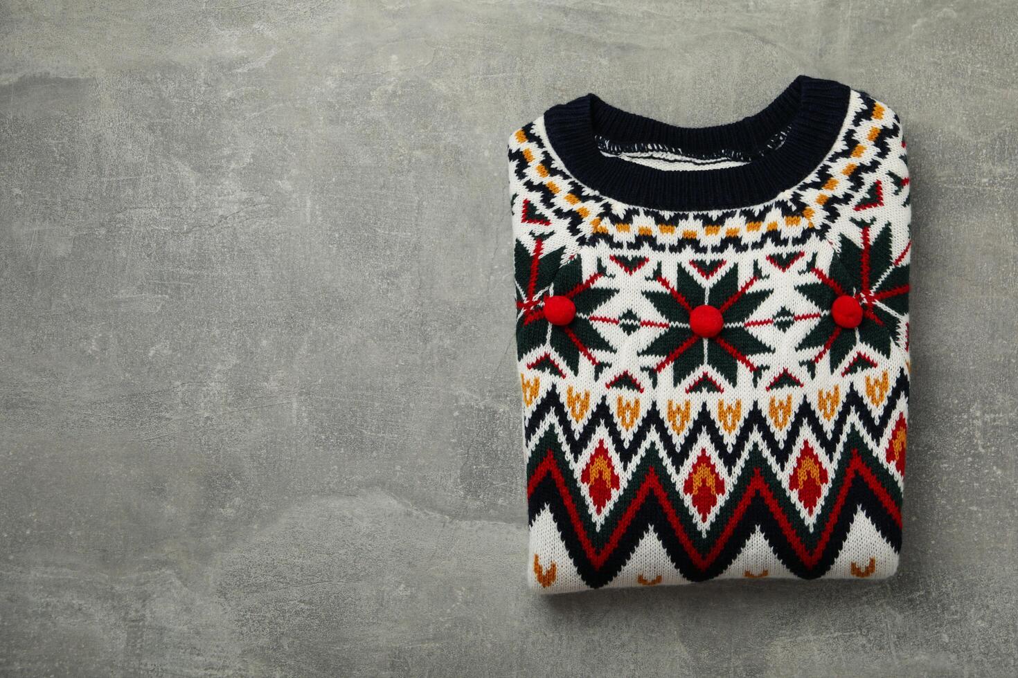 Knitted sweater on gray background, space for text photo