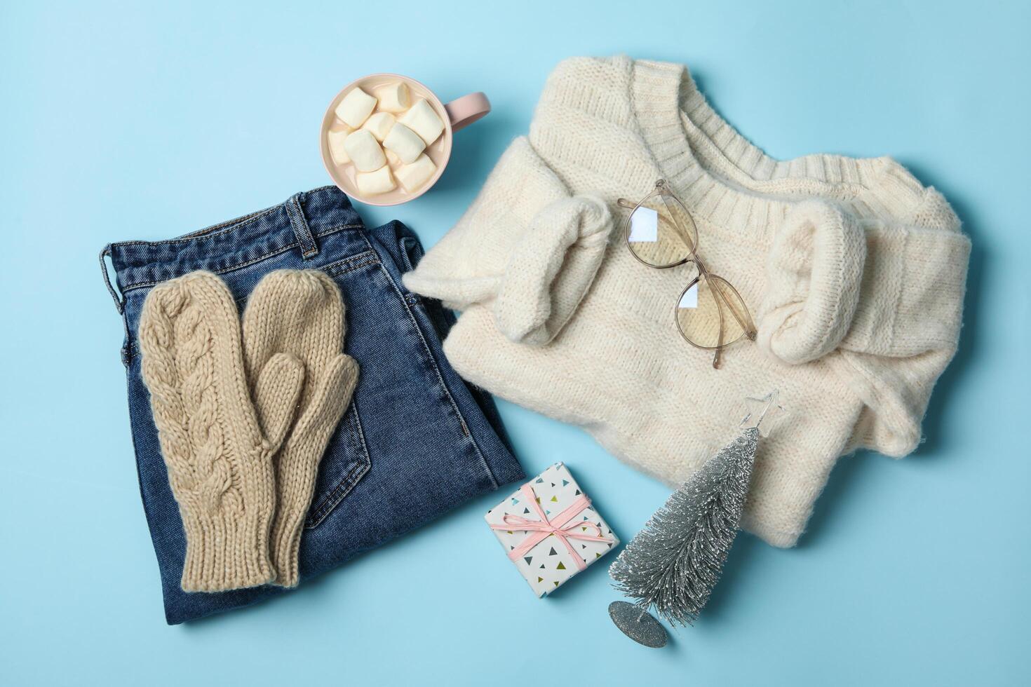 Winter concept with sweater and gift box on blue background photo