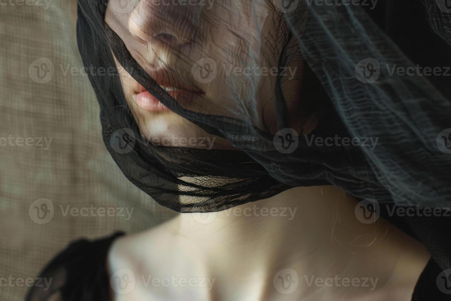 Woman posing with black veil covering her face photo