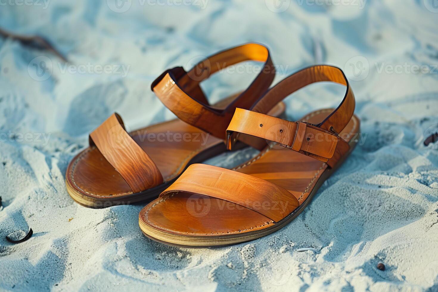 Leather sandals resting on the sand of a tropical beach photo