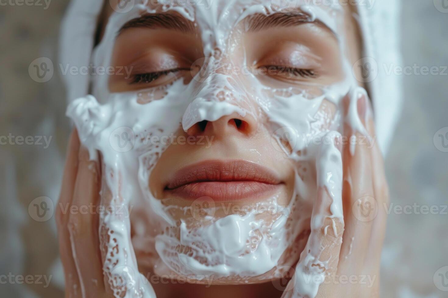 Young woman applying cleansing foam mask on face in spa salon photo