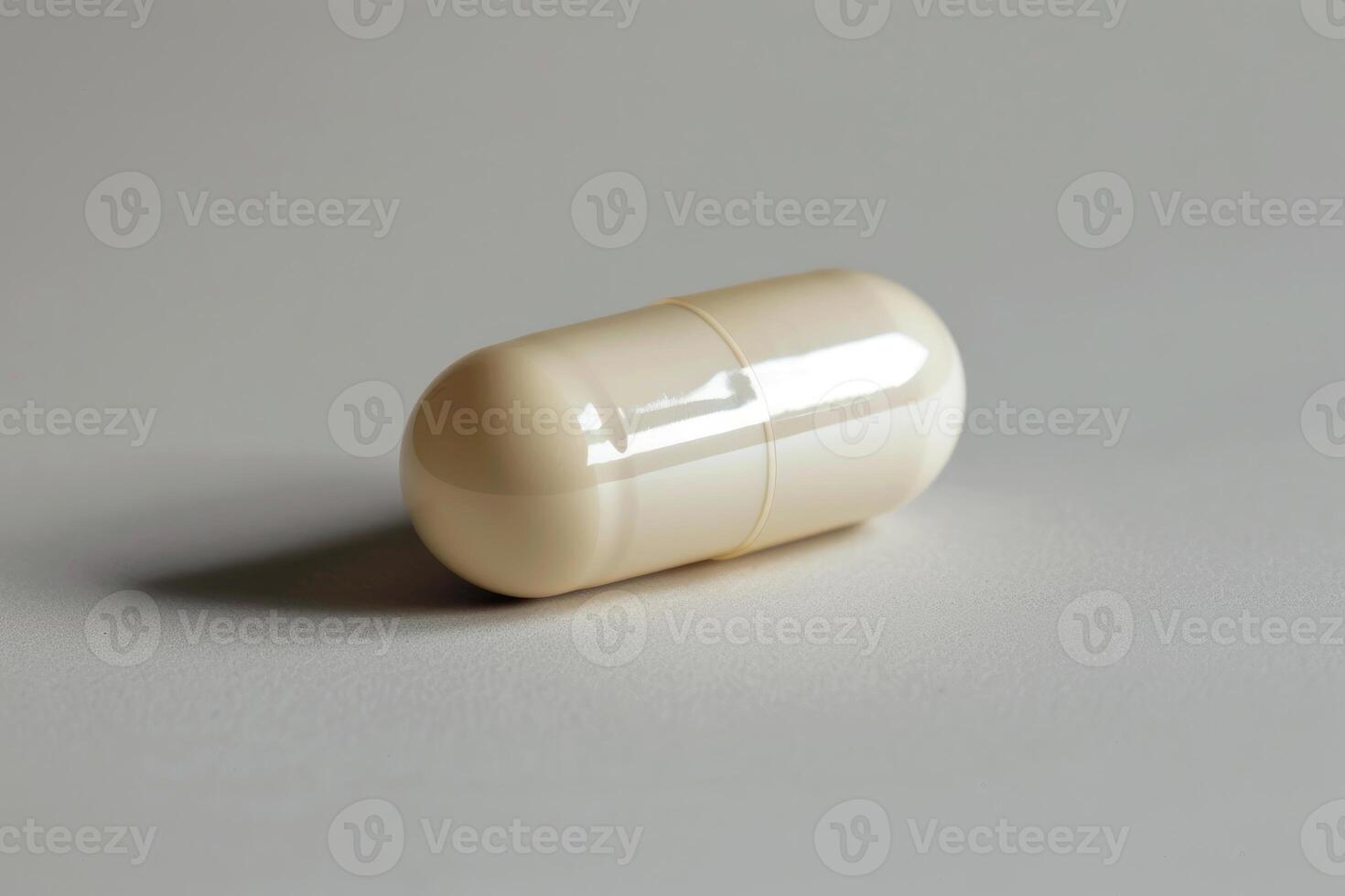 Single beige pill lying on a white surface photo