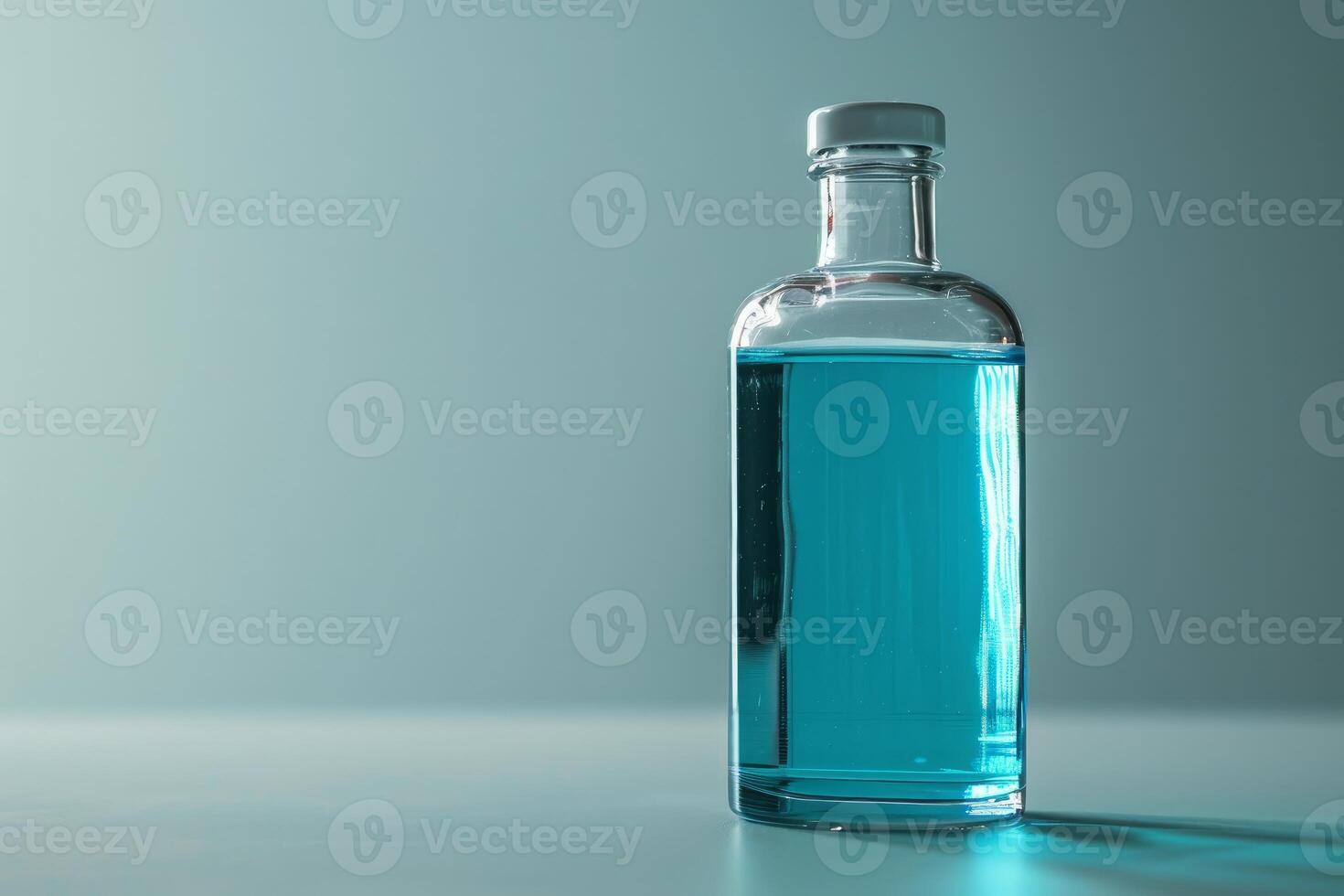Glass bottle filled with blue liquid standing on surface with copy space photo