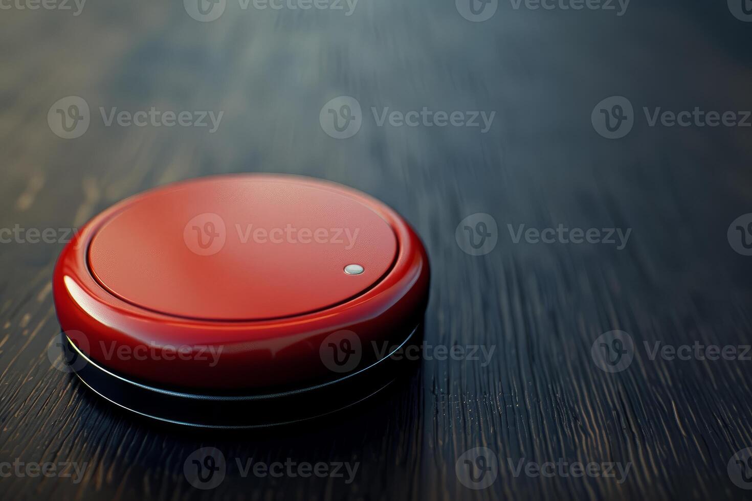 Red button sitting on dark wooden surface is glowing photo