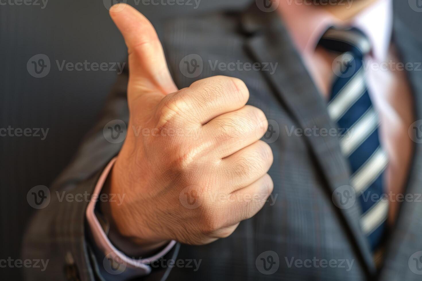 Businessman showing thumb up gesture approving successful business agreement photo