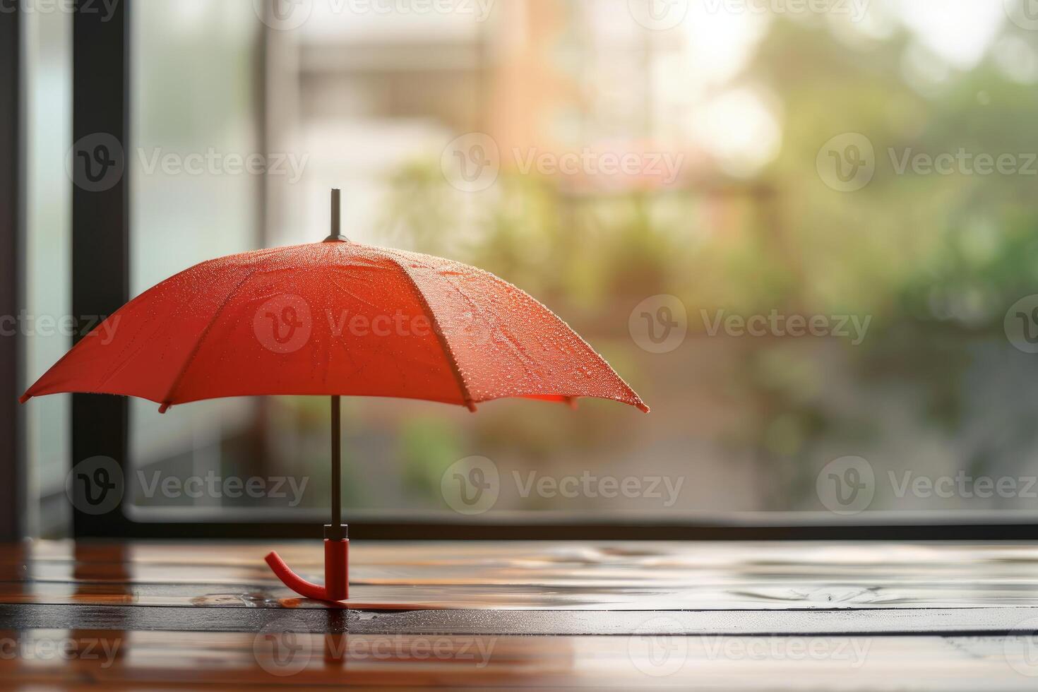 Red umbrella with rain drops on wooden table by window during rainy season photo