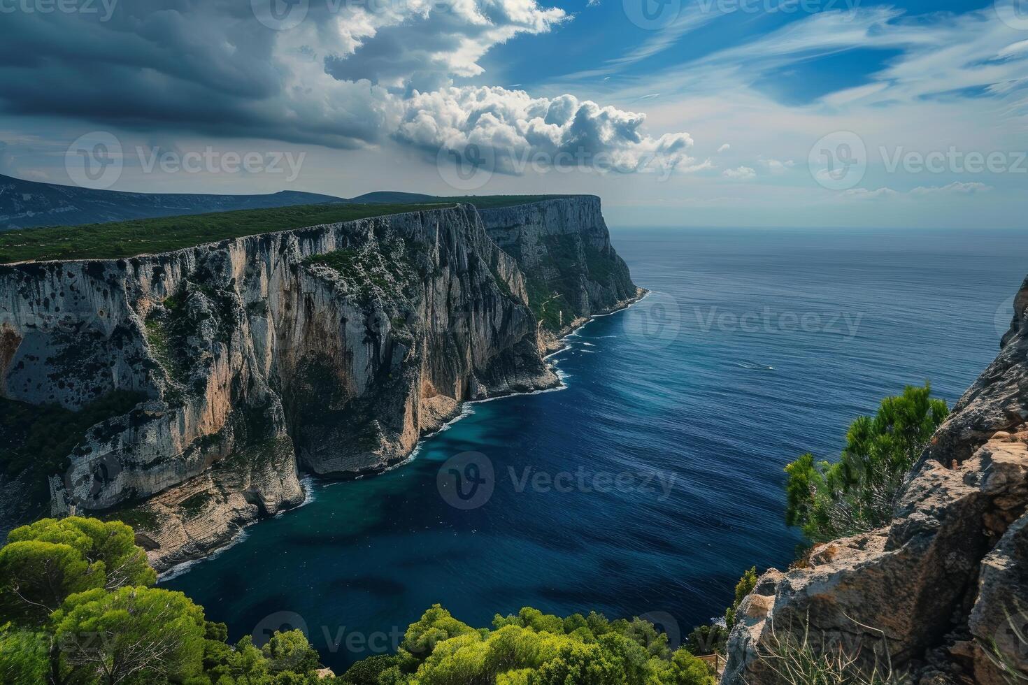 Dramatic coastline emerging from blue ocean under cloudy sky photo