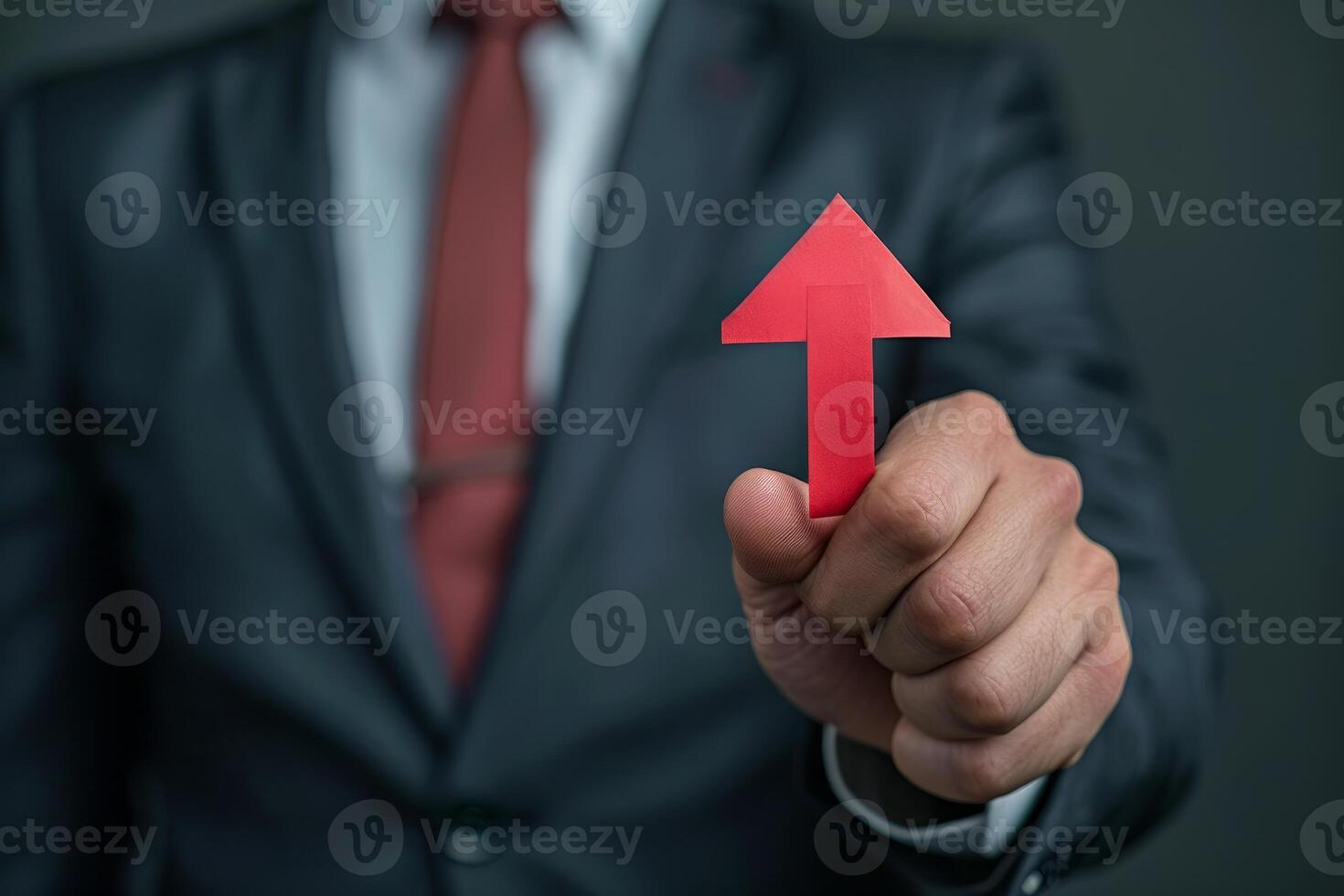 Businessman holding red up arrow representing growth and success photo