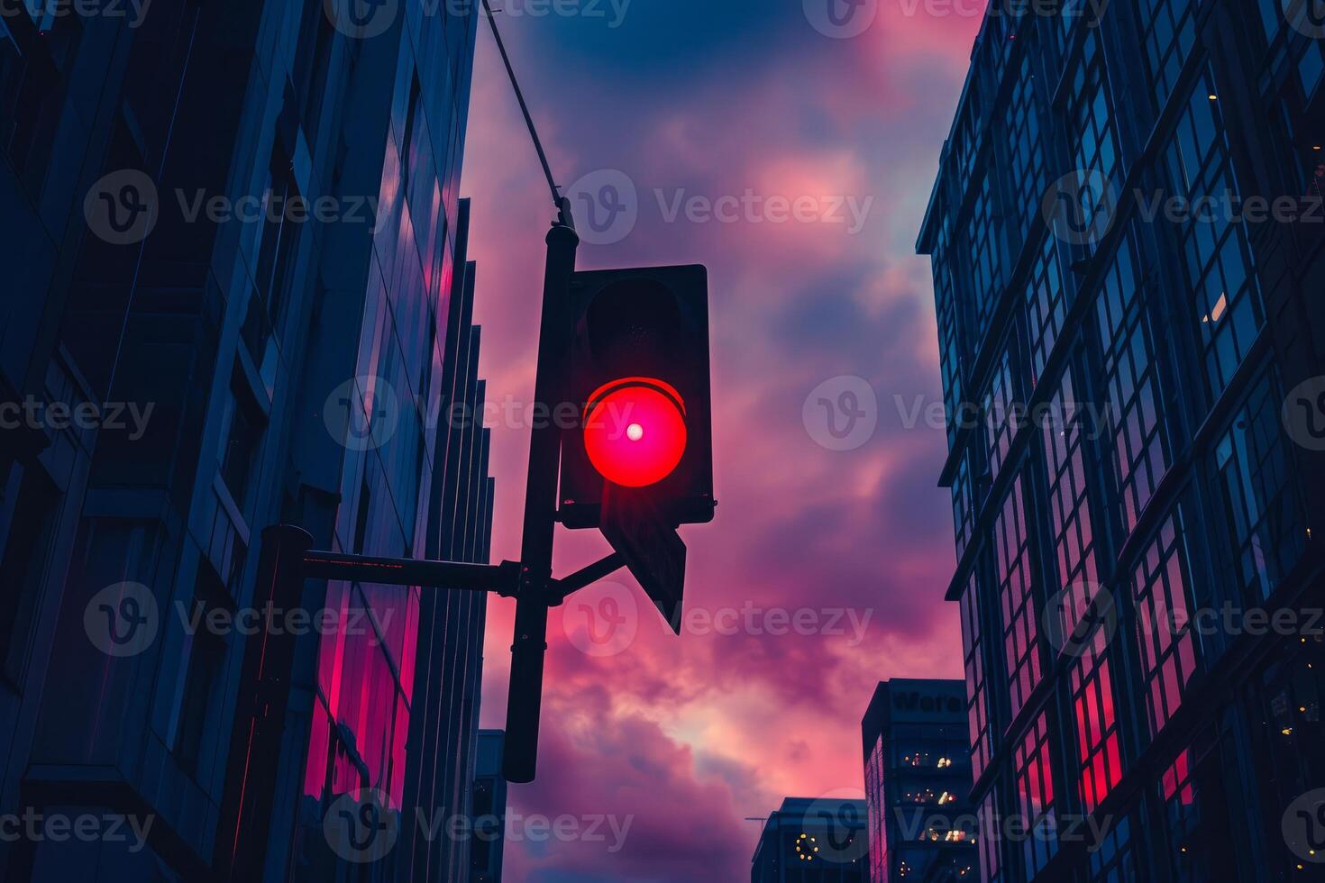 Red traffic light showing stop signal at dusk in urban scenery photo
