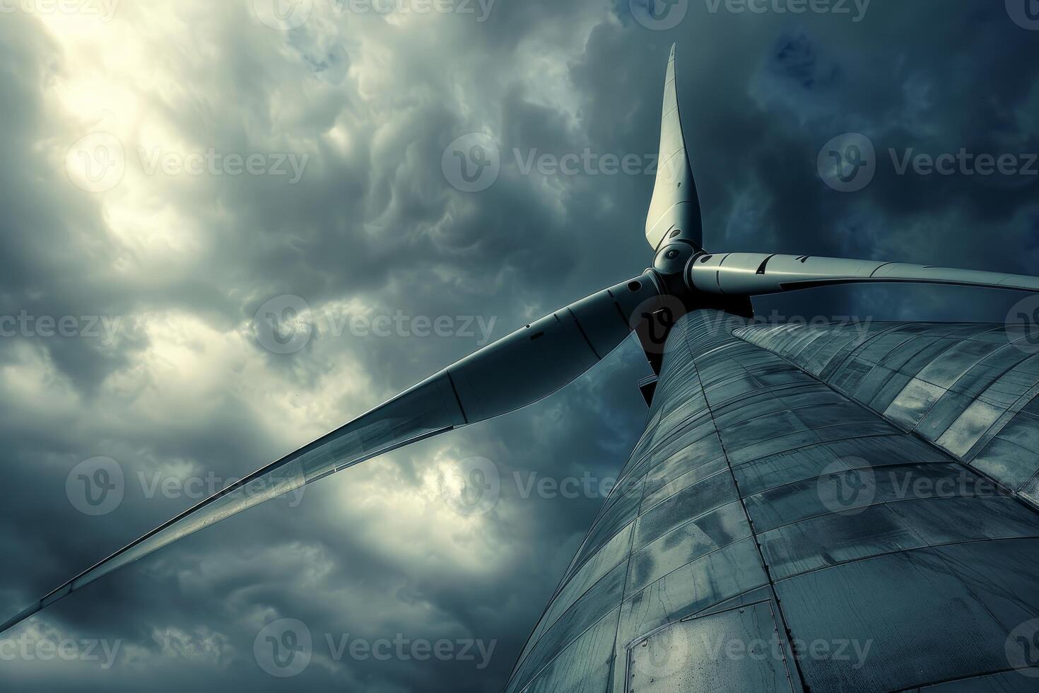 Wind turbine generating green energy under stormy sky photo