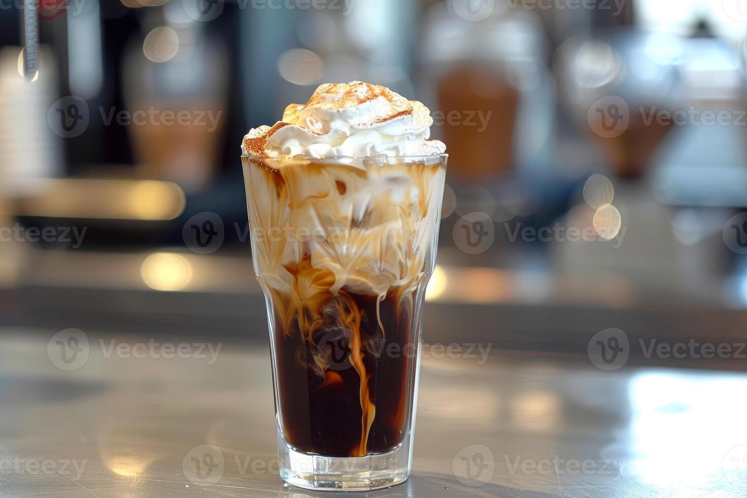 Iced coffee with whipped cream and cinnamon standing on a bar photo
