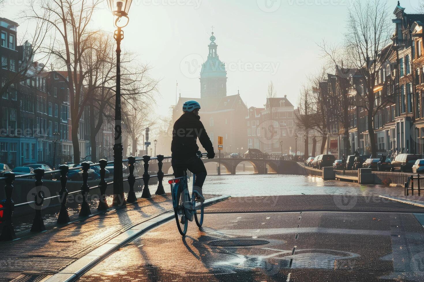 Man riding a bicycle in amsterdam along a canal in winter photo
