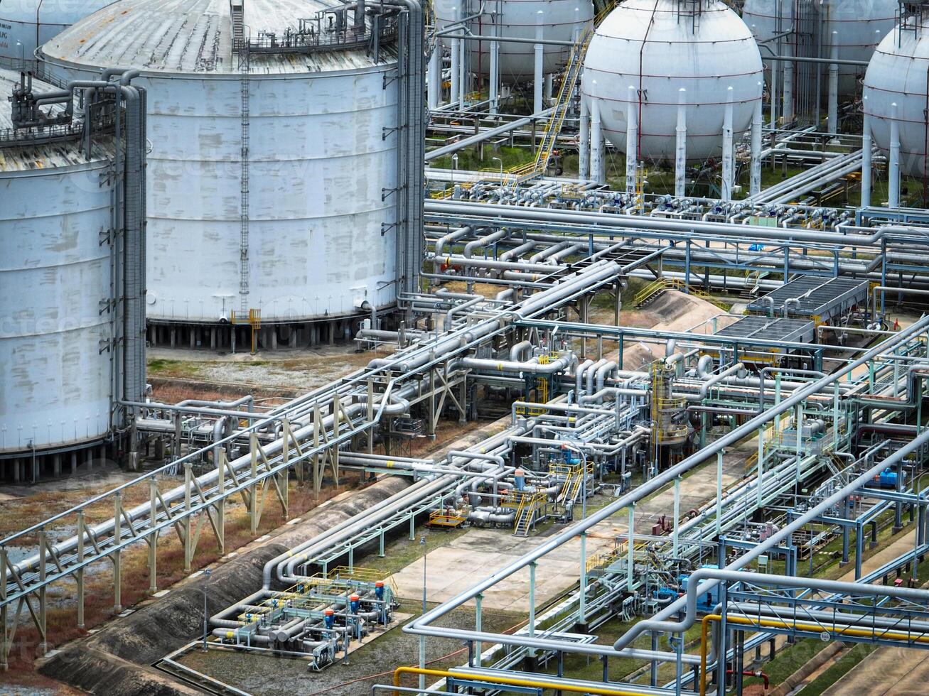 Industrial oil refinery and petrochemical plant with extensive steel pipelines and gas storage tanks. Infrastructure for the energy and fuel. Oil and gas refinery plant. Network of pipes and tanks. photo