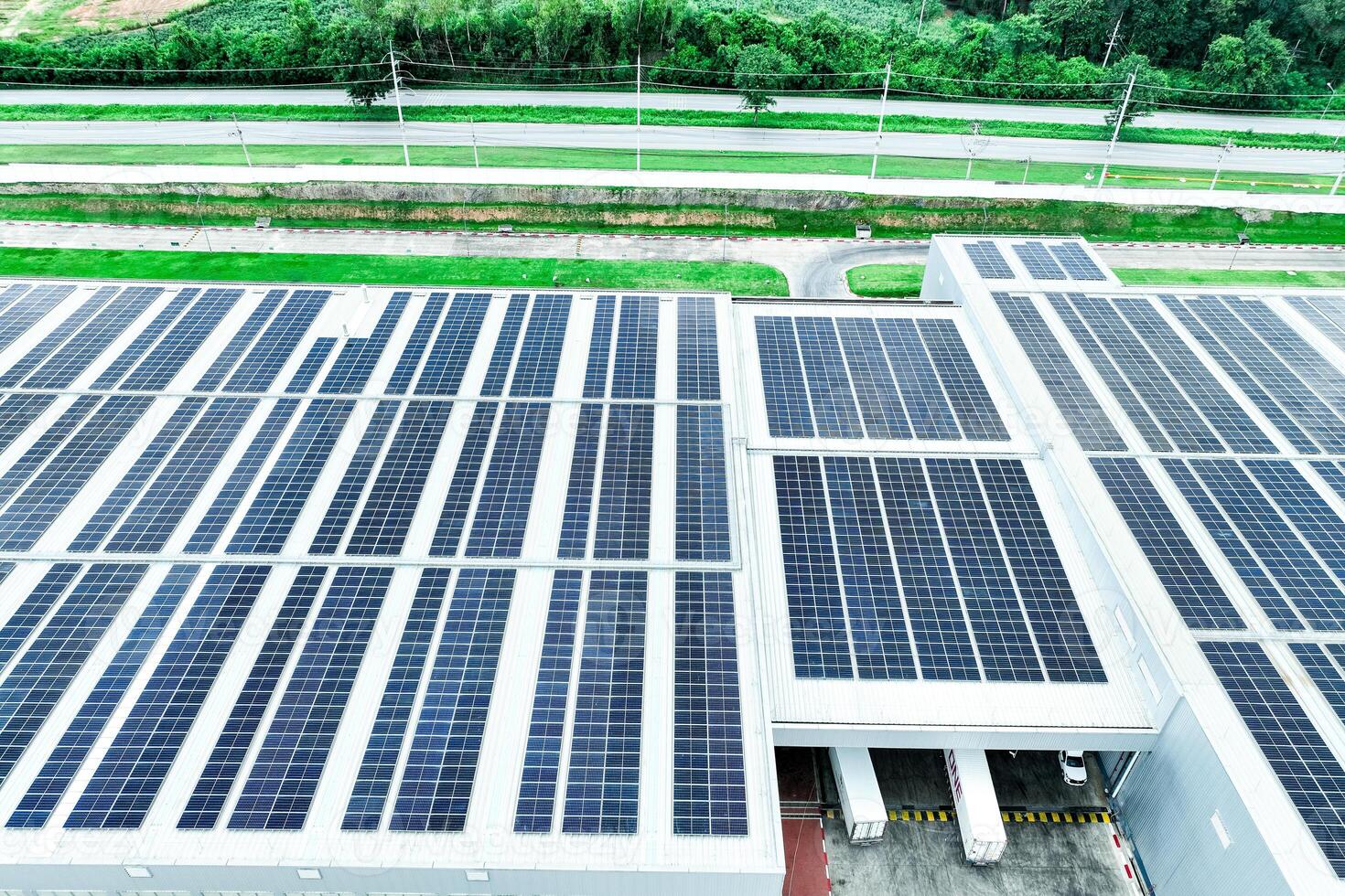 Solar energy for factory and warehouse building. Solar panels on roof of industrial plant. Commercial solar power. Rooftop solar power. Rooftop renewable energy system. Sustainable green energy. photo