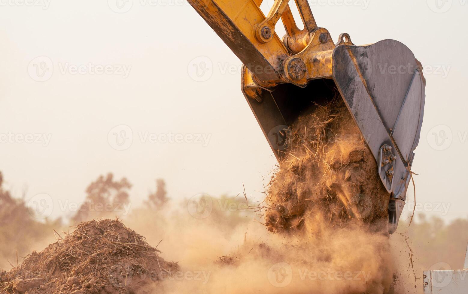 Backhoe working by digging soil at construction site bucket of crawler excavator breaking ground for new development project earth moving machine in action. Foundation work on construction project. photo