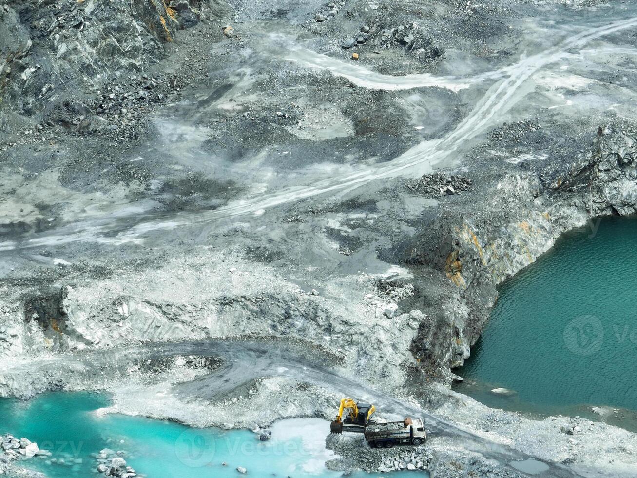 Open pit mine industry. Limestone quarry with backhoe and truck in operation. Heavy machinery in mining industry and construction material supply. Landscape of resource extraction in a industrial site photo