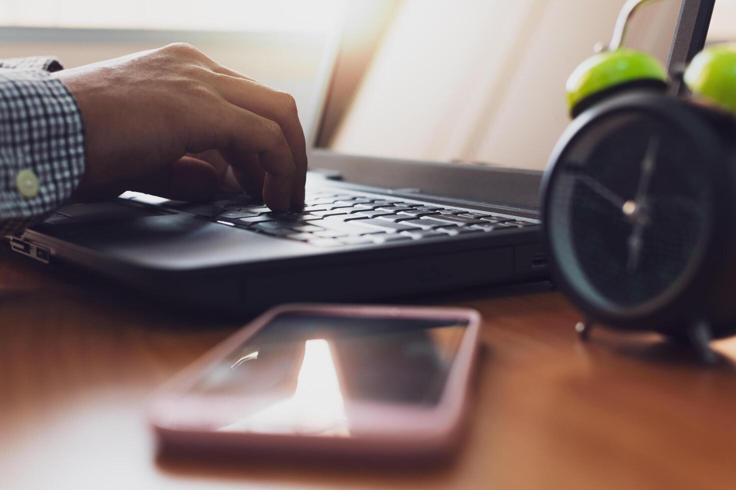 Hands of businessman typing with laptop on working desk in office. photo