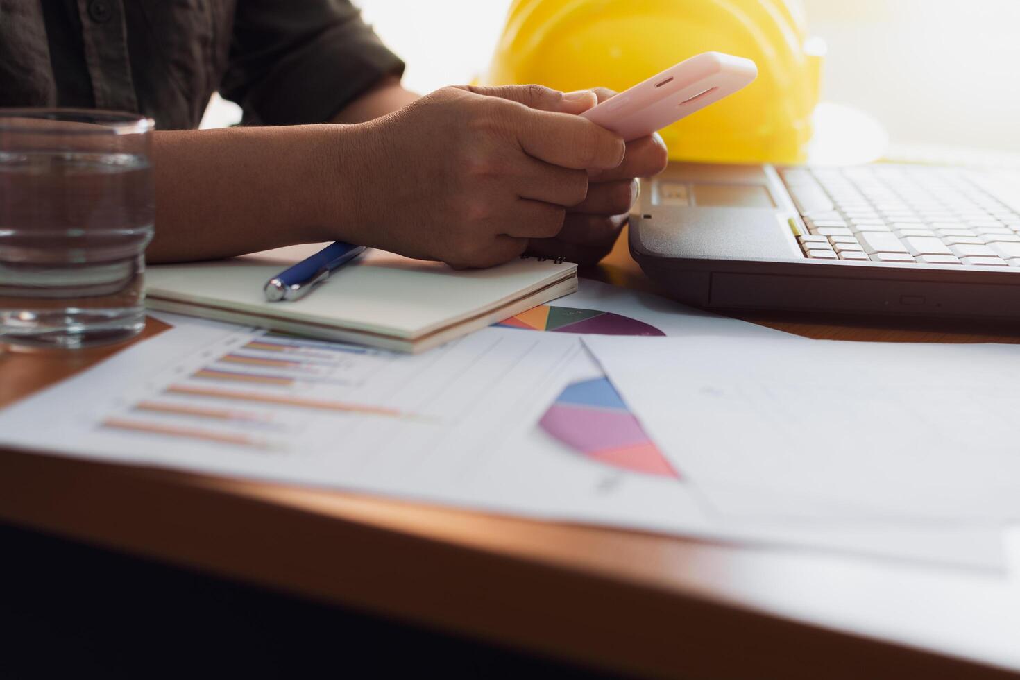 Hands of architect woman using mobilephone on working desk. photo