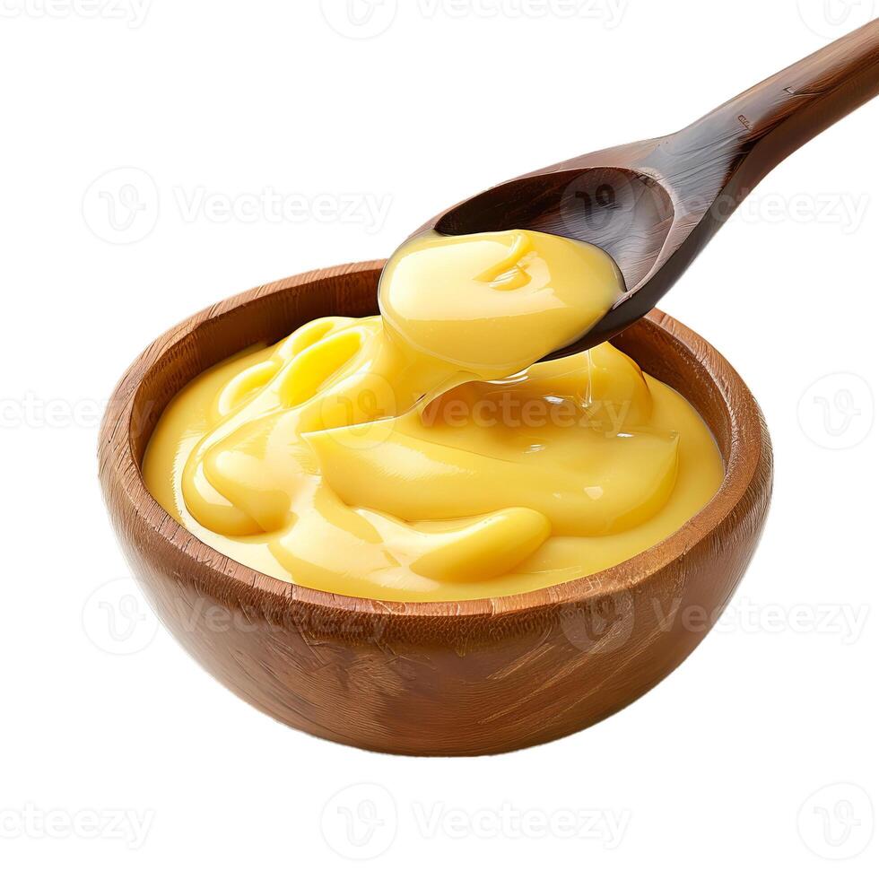 Wooden spoon dripping delicious custard or pudding into bowl photo