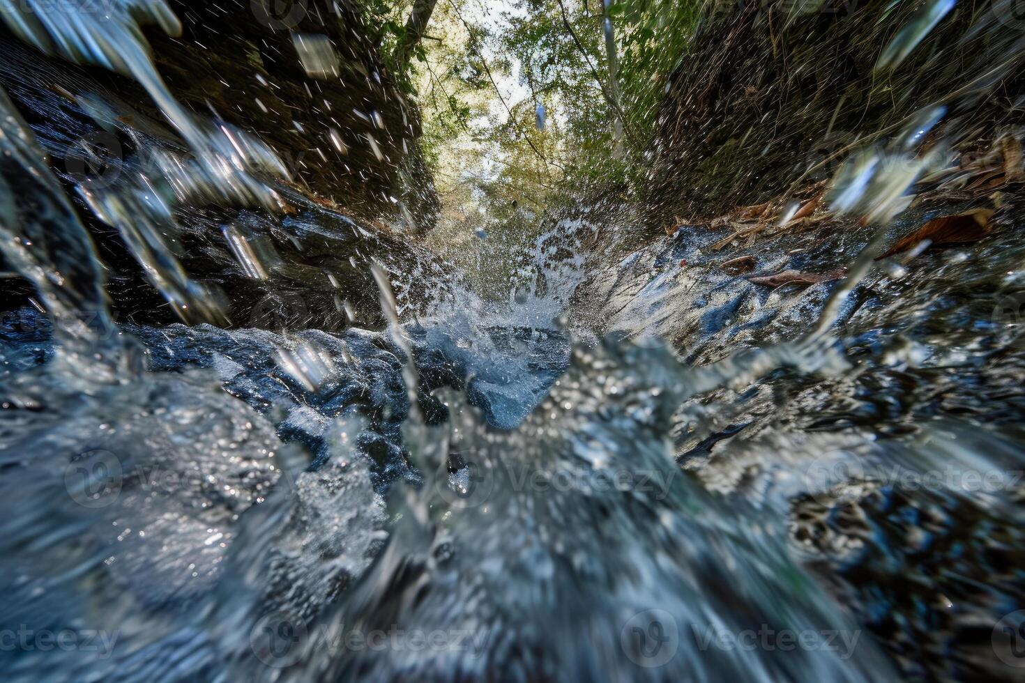 Water rushing through rocks in forest stream on sunny day photo