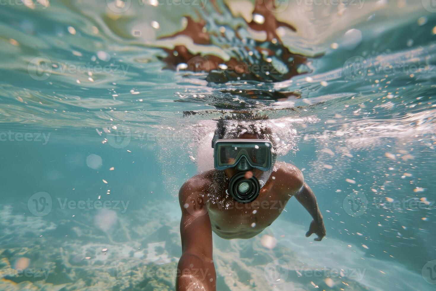 Young man is enjoying snorkeling in tropical blue water photo