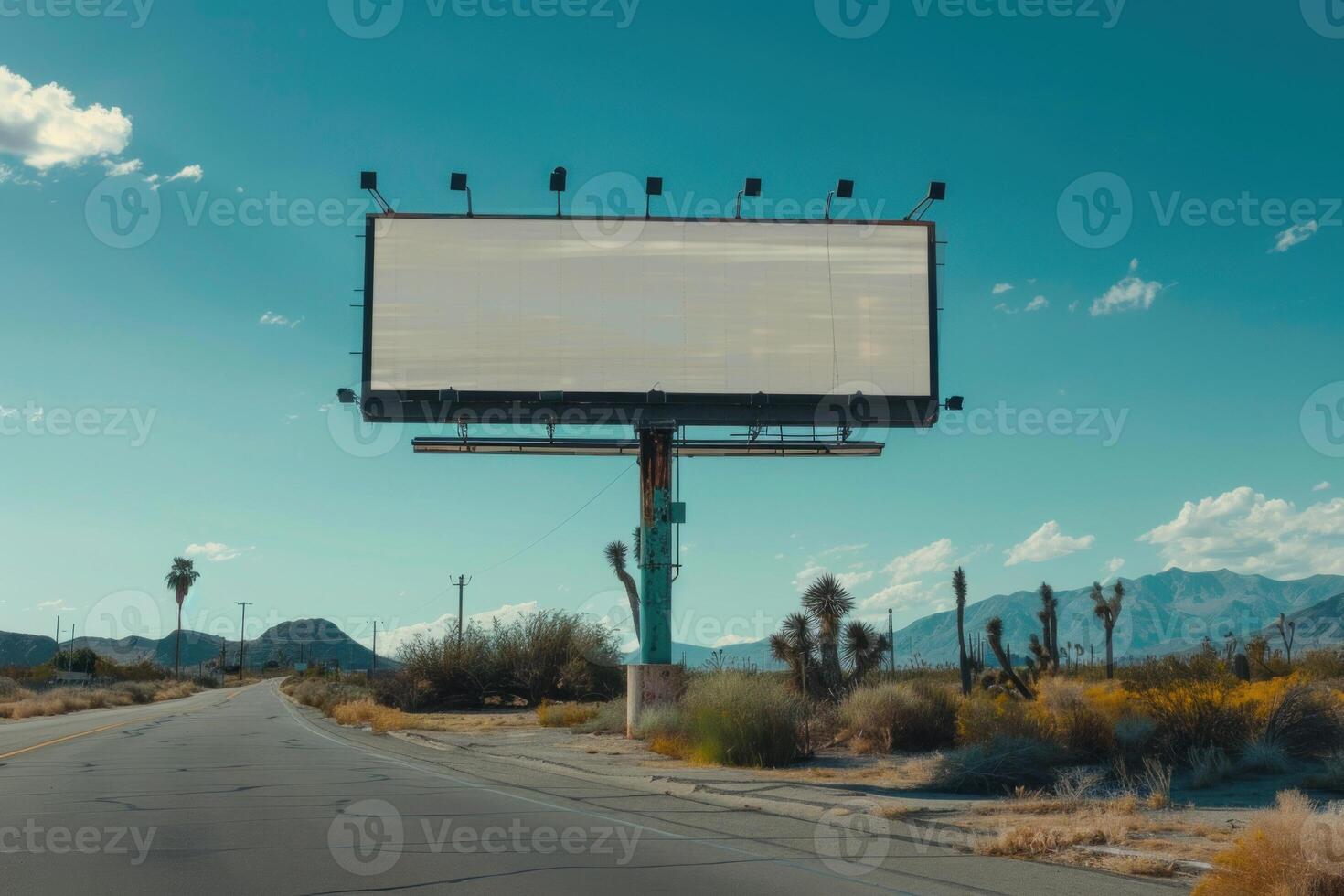 Large blank billboard by the road leading to the mountains photo