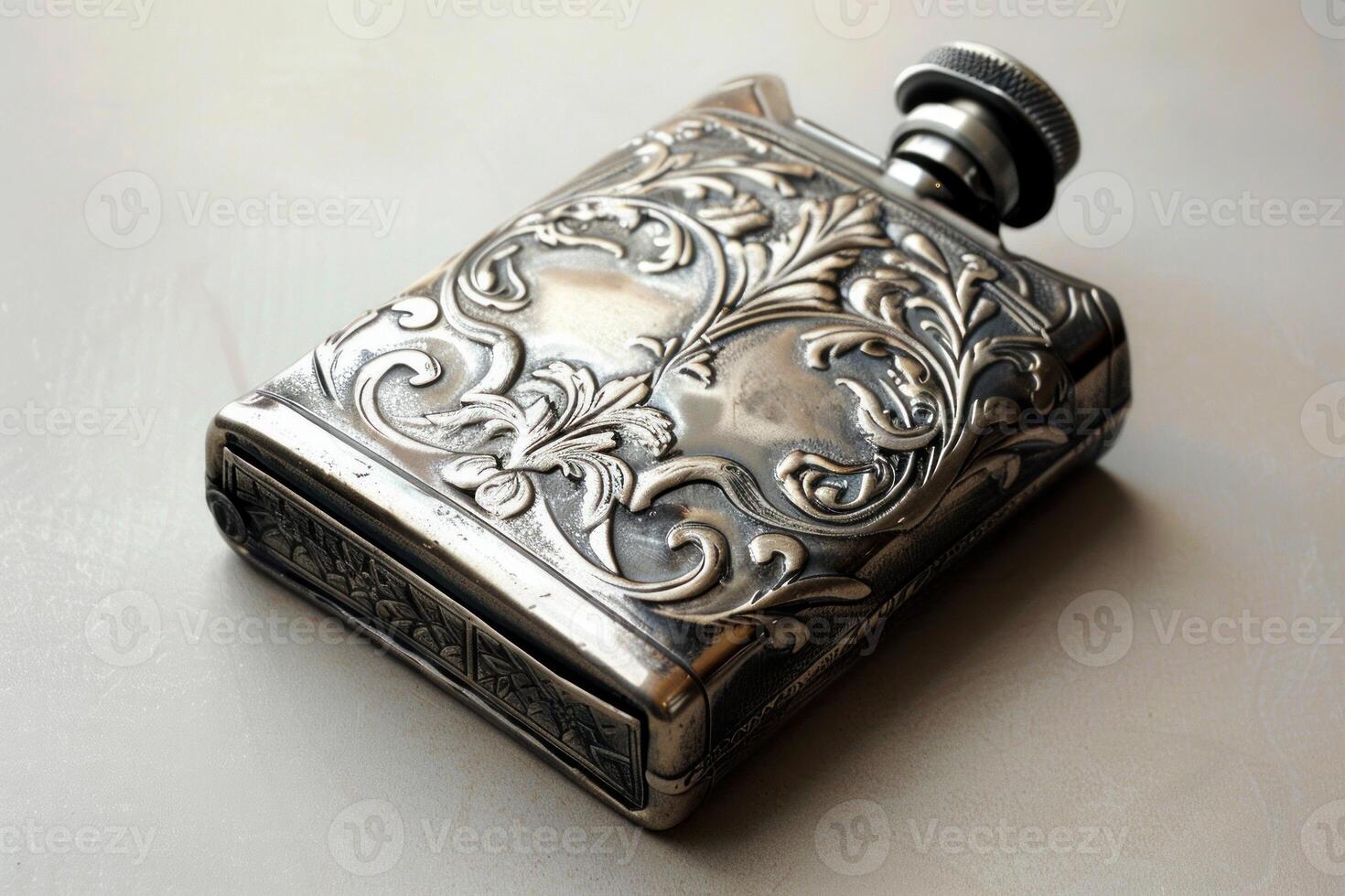 Antique engraved silver flask is lying on a table photo