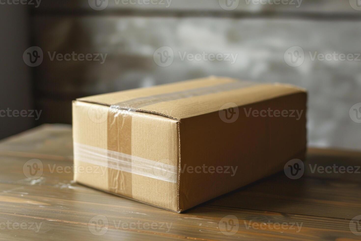 Cardboard box standing on wooden table with brick wall background photo