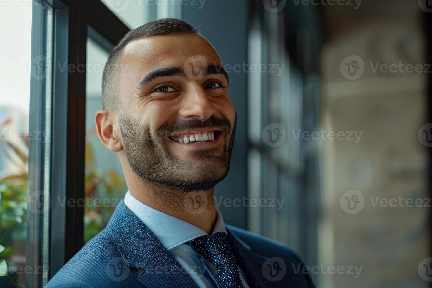 Businessman smiling by the window in office building photo