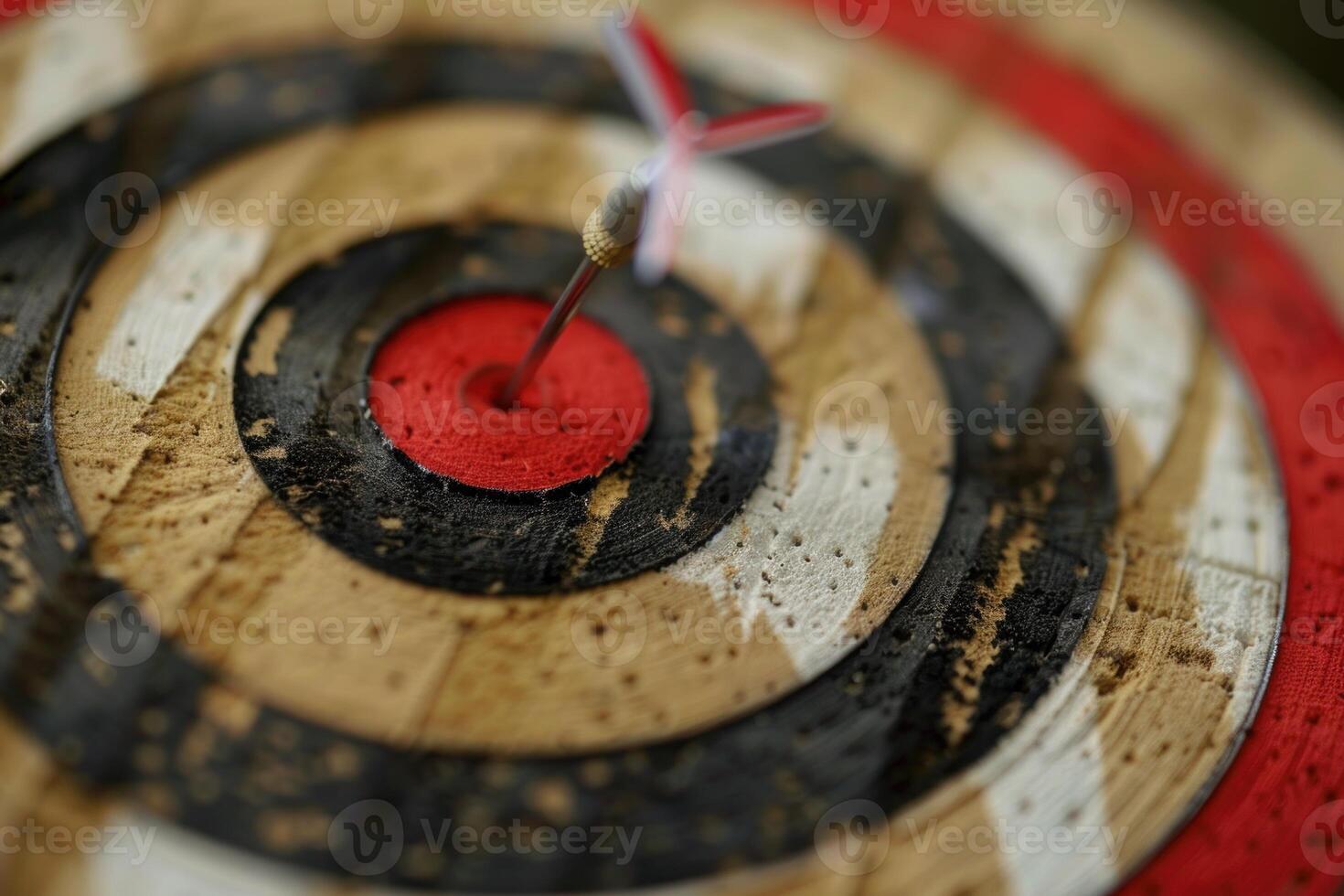Red dart hitting the center of old target on wood photo