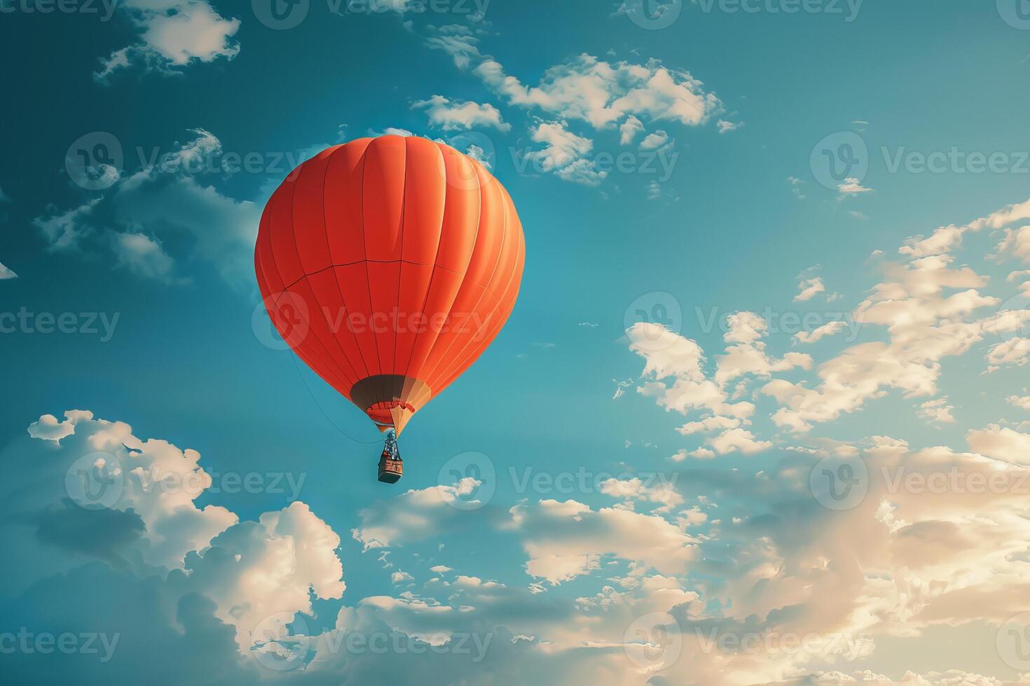 Bright orange hot air balloon flying in cloudy sky photo