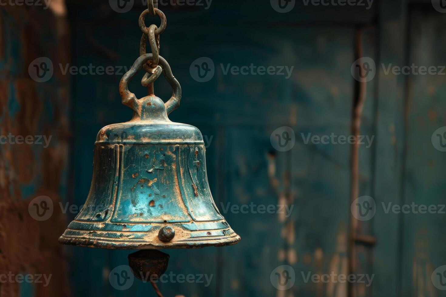 Old weathered green metal bell hanging with rusty chain photo