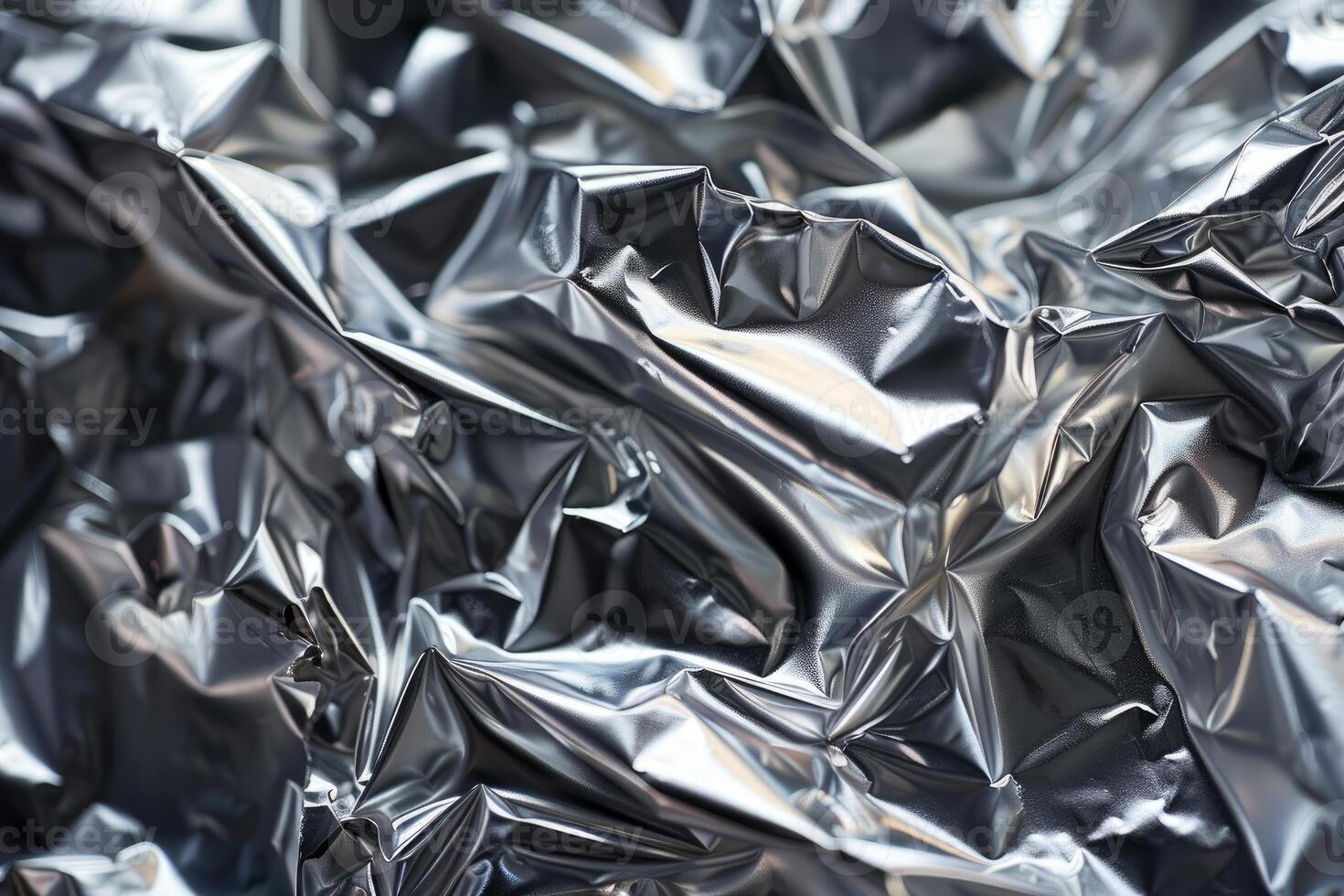 Abstract background of crumpled silver aluminum foil reflecting light photo