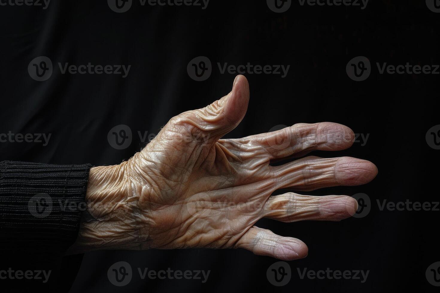 Senior showing open hand with wrinkled skin on black background photo